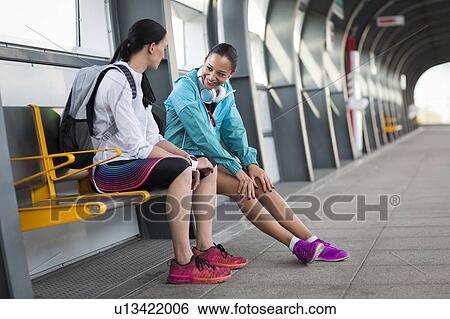 Stock Photograph - Women sitting on railway platform. Fotosearch