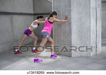 Women stretching against wall View Large Photo Image Stock Photography - Women stretching against wall. Fotosearch