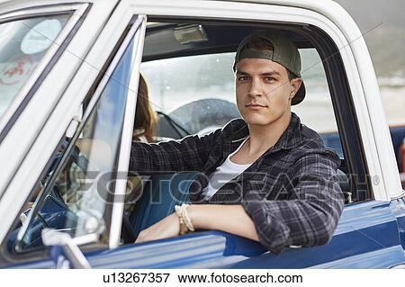 Young man in car View Large Photo Image Stock Photo - Young man in car. Fotosearch