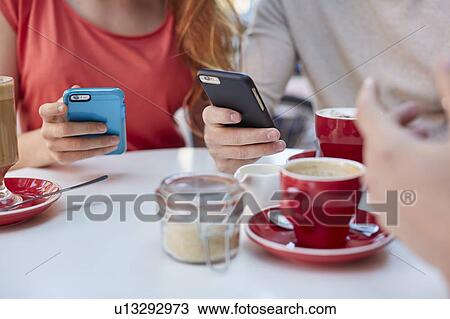 Young people in cafe using smartphones View Large Photo Image Stock Image - Young people in cafe using smartphones. Fotosearch