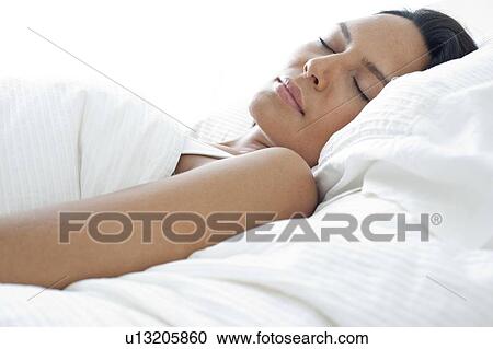 Stock Image - Young woman asleep in bed. Fotosearch