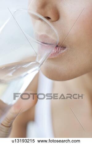 Stock Photography - Young woman drinking a glass of water. Fotosearch