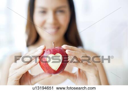 Young woman holding apple with heart View Large Photo Image Stock Image - Young woman holding apple with heart. Fotosearch