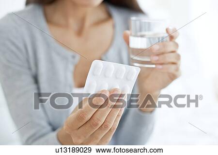 Young woman holding blister pack View Large Photo Image Stock Photo - Young woman holding blister pack. Fotosearch