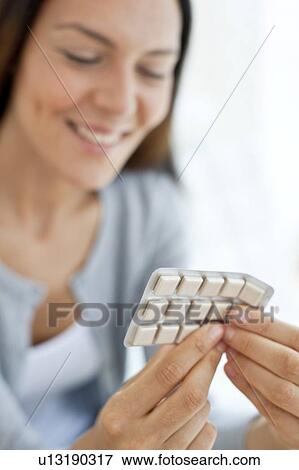 Stock Photo - Young woman holding nicotine gum. Fotosearch