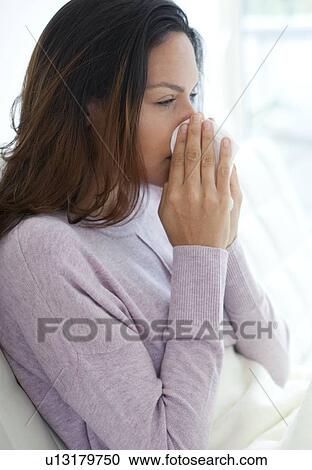 Stock Image - Young woman in bed with cold. Fotosearch