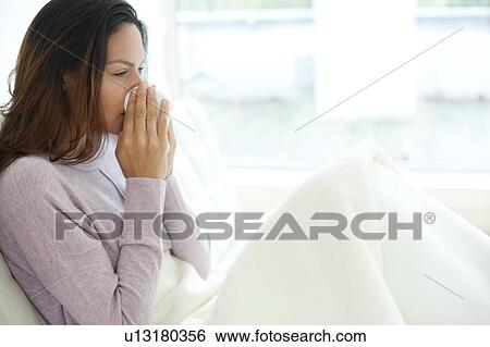 Stock Photograph - Young woman in bed with cold. Fotosearch