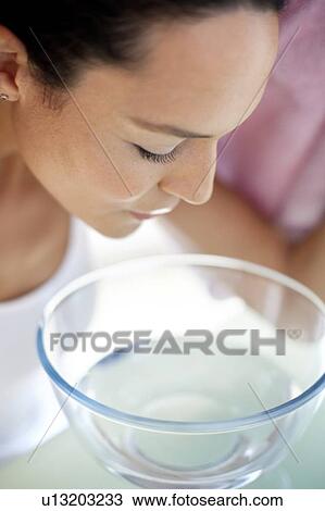 Stock Image - Young woman inhaling steam. Fotosearch