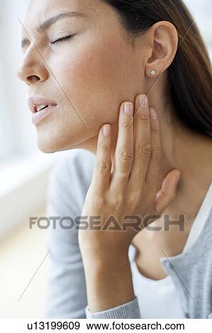 Stock Photo - Young woman touching neck. Fotosearch