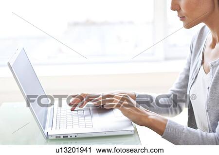 Young woman using her laptop View Large Photo Image Stock Image - Young woman using her laptop. Fotosearch