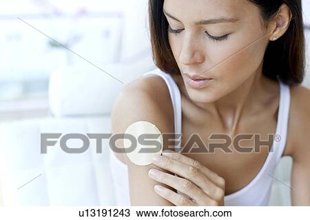 Stock Image - Young woman wearing nicotine patch. Fotosearch