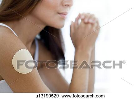Young woman wearing nicotine patch View Large Photo Image Stock Photo - Young woman wearing nicotine patch. Fotosearch