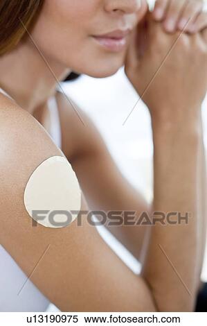Stock Photography - Young woman wearing nicotine patch. Fotosearch