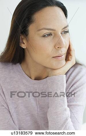 Stock Photo - Young woman with hand on chin. Fotosearch