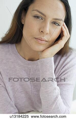 Stock Photography - Young woman with hand on chin. Fotosearch