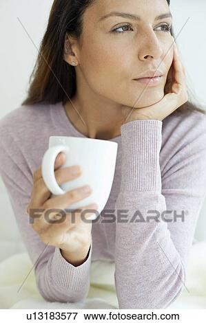 Young woman with hot drink View Large Photo Image Stock Photo - Young woman with hot drink. Fotosearch