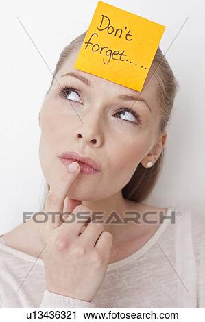 Stock Image - Young woman with sticky note. Fotosearch