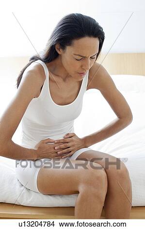 Young woman with stomach cramps View Large Photo Image Picture - Young woman with stomach cramps. Fotosearch