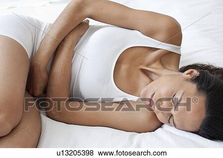 Stock Photo - Young woman with stomach cramps. Fotosearch