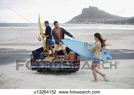 Young woman with surfboard on beach View Large Photo Image Stock Image - Young woman with surfboard on beach. Fotosearch