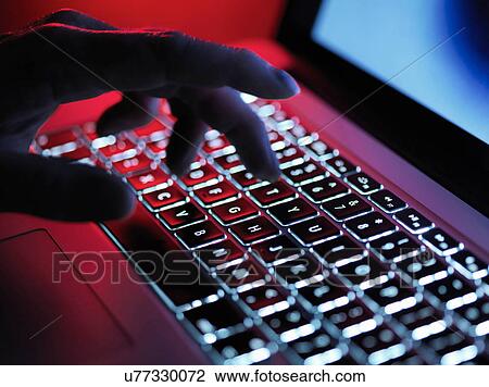 A dark mystery hand typing on a laptop computer at night View Large Photo Image Stock Image - A dark mystery hand typing on a laptop computer at night. Fotosearch
