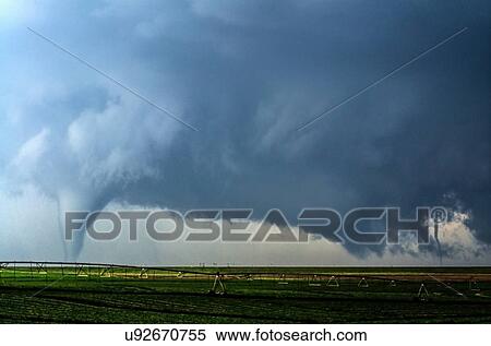 Stock Photography - A supercell thunderstorm produces two tornadoes at once in a farm field south of Dodge City, Kansas. Fotosearch