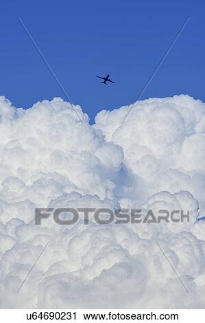 Airplane flying over large cloud View Large Photo Image Stock Image - Airplane flying over large cloud. Fotosearch