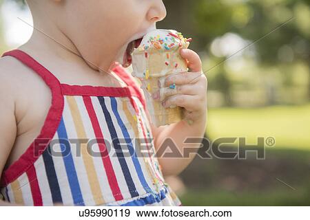 Baby girl (18-23 months) eating ice-cream View Large Photo Image Stock Photo - Baby girl (18-23 months) eating ice-cream. Fotosearch