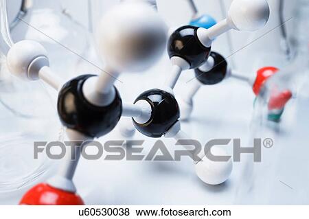 Stock Photo - Ball and stick molecular model and laboratory flasks. Fotosearch