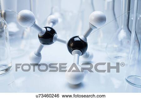 Stock Photograph - Ball and stick molecular model of ethane, surrounded by laboratory flasks. Fotosearch