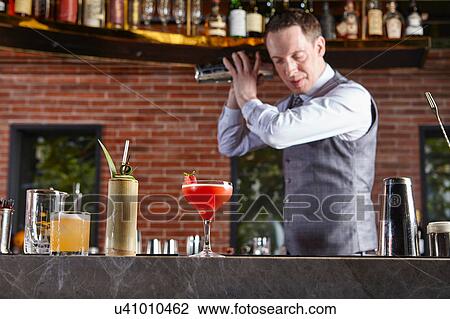 Bartender shaking cocktail shaker View Large Photo Image Stock Image - Bartender shaking cocktail shaker. Fotosearch