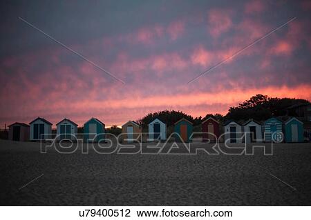 Stock Image - Beach huts in a row at sunset, Southwold, Suffolk, UK. Fotosearch