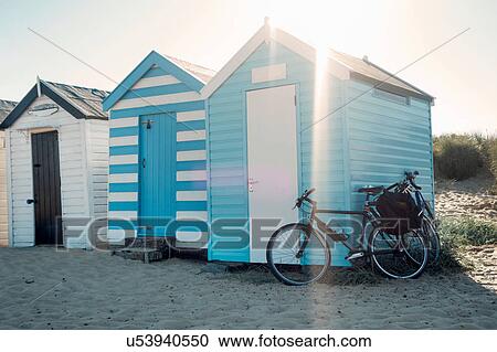 Stock Image - Bicycle leaning against row of beach huts, Southwold, Suffolk, UK. Fotosearch