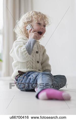 Blond girl (4-5) playing with mobile phone View Large Photo Image Stock Photograph - Blond girl (4-5) playing with mobile phone. Fotosearch