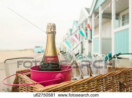 Stock Image - Bottle of champagne and champagne flute in picnic basket, Southwold, Suffolk, UK. Fotosearch