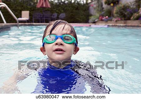 Stock Photo - Boy (4-5) playing in pool. Fotosearch