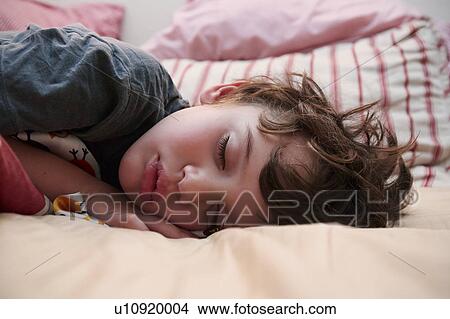 Boy (4-5) sleeping in bed View Large Photo Image Picture - Boy (4-5) sleeping in bed. Fotosearch