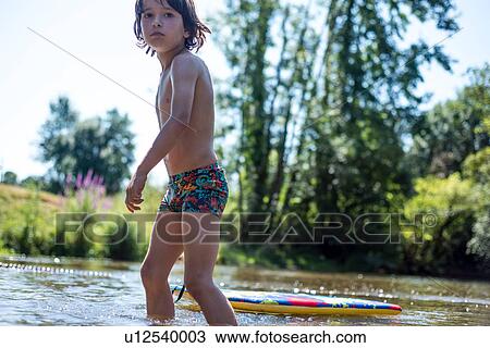 Boy ankle deep in water with body board View Large Photo Image Stock Image - Boy ankle deep in water with body board. Fotosearch