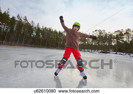 Stock Image - Boy balancing whilst ice skating on frozen lake, Gavle, Sweden. Fotosearch