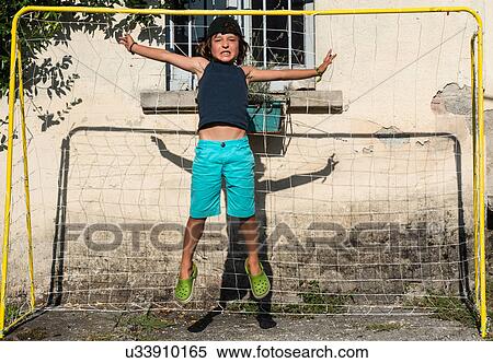 Boy in football goal jumping in mid air View Large Photo Image Stock Photography - Boy in football goal jumping in mid air. Fotosearch