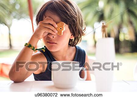 Boy looking through hole in biscuit View Large Photo Image Stock Image - Boy looking through hole in biscuit. Fotosearch