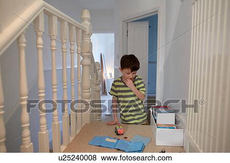 Boy on staircase playing with toys View Large Photo Image Stock Photo - Boy on staircase playing with toys. Fotosearch