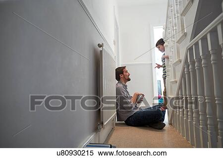 Boy on staircase talking and pointing to father View Large Photo Image Stock Photography - Boy on staircase talking and pointing to father. Fotosearch