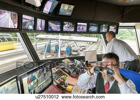 Stock Image - Bridge control workers in control room. Fotosearch