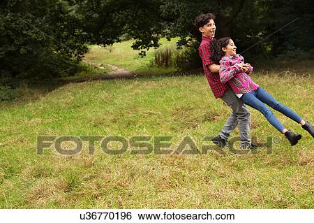 Brother and sister outdoors, fooling around, brother swinging sister around View Large Photo Image Stock Photograph - Brother and sister outdoors, fooling around, brother swinging sister around. Fotosearch