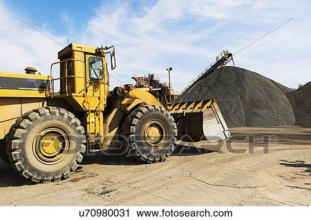 Stock Image - Bulldozer and heap of gravel. Fotosearch