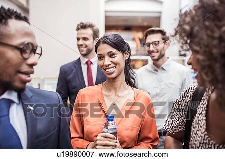 Stock Photo - Business team and client having discussion in office. Fotosearch