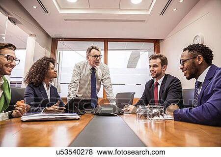 Business team having discussion at boardroom table meeting View Large Photo Image Stock Photo - Business team having discussion at boardroom table meeting. Fotosearch