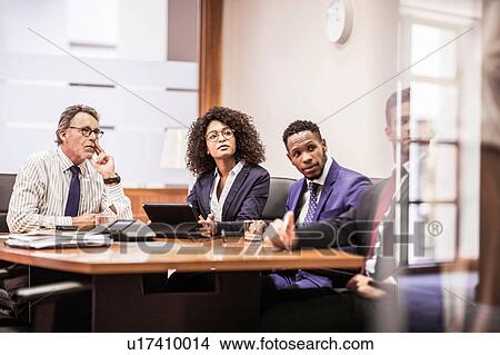 Picture - Business team listening at boardroom table. Fotosearch