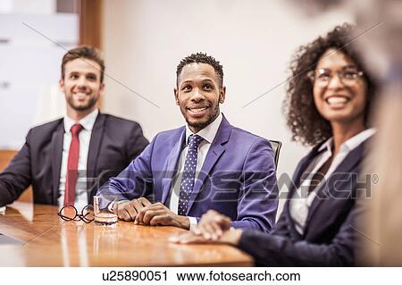 Business team listening at boardroom table View Large Photo Image Stock Image - Business team listening at boardroom table. Fotosearch